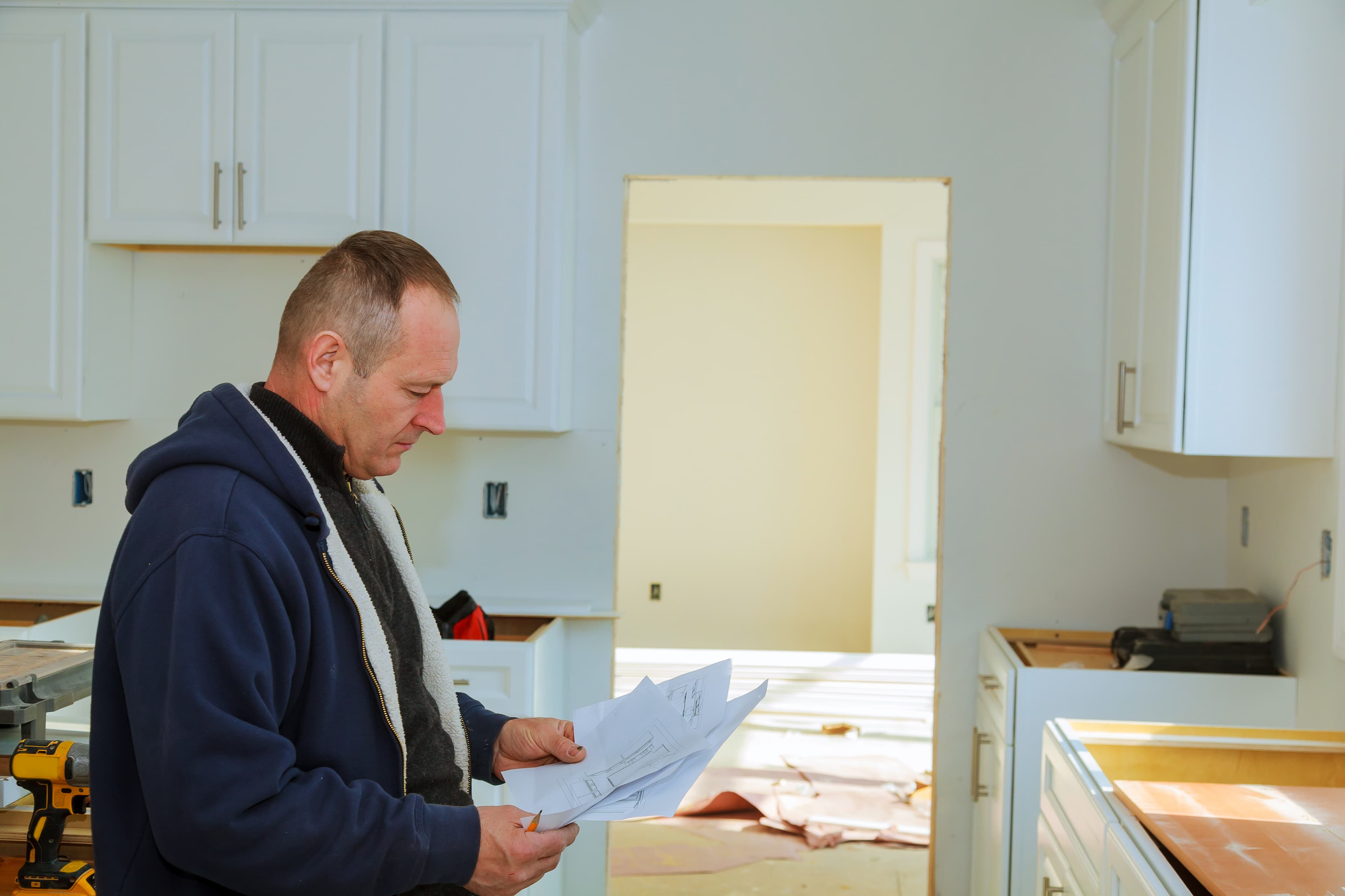 Man reviewing kitchen renovation plans in Australia.