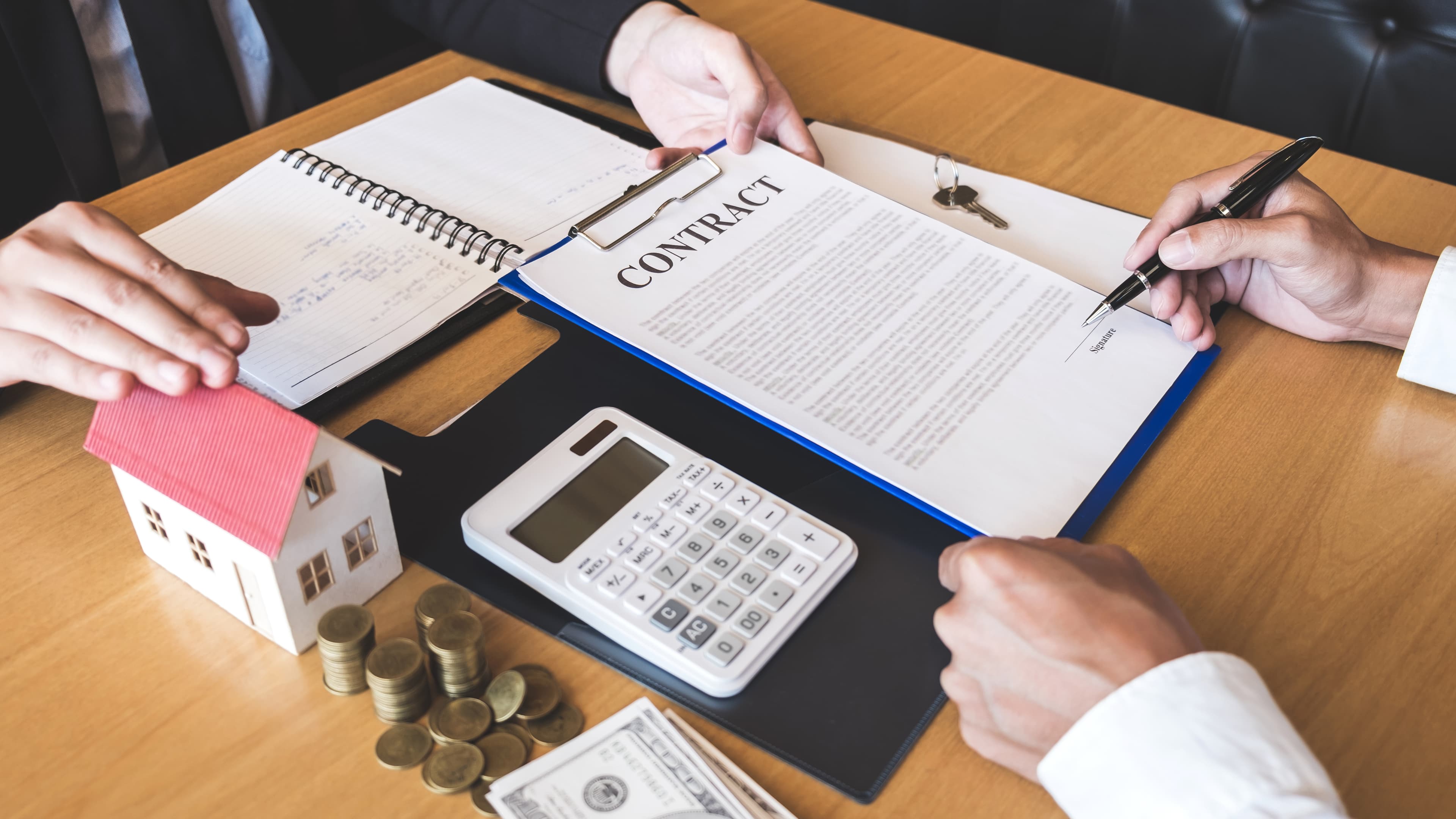 People discussing fixed-price vs cost-plus building contracts with model house and calculator.