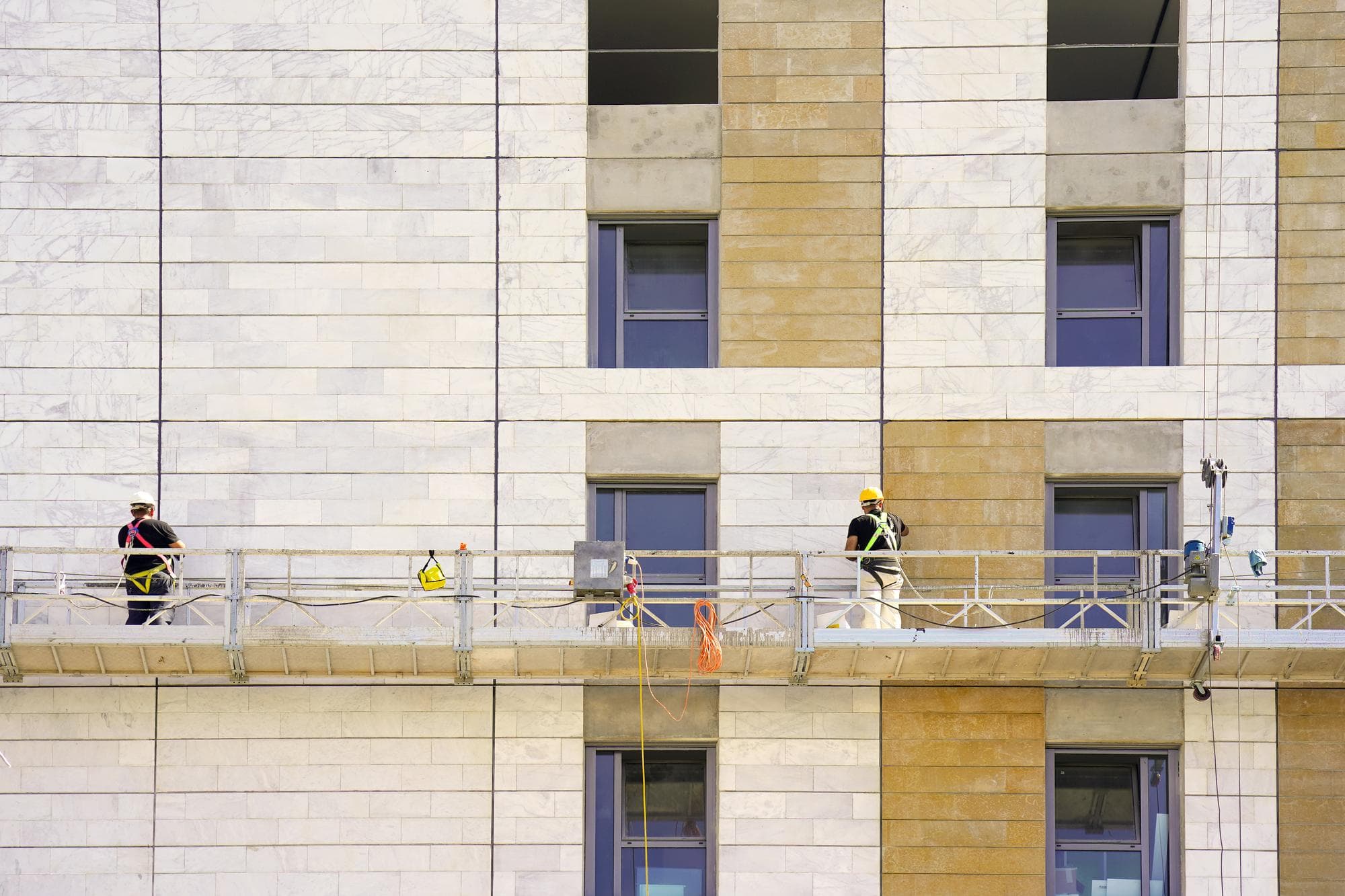 High rise facade refurbishment in progress on Gold Coast with workers on scaffolding.