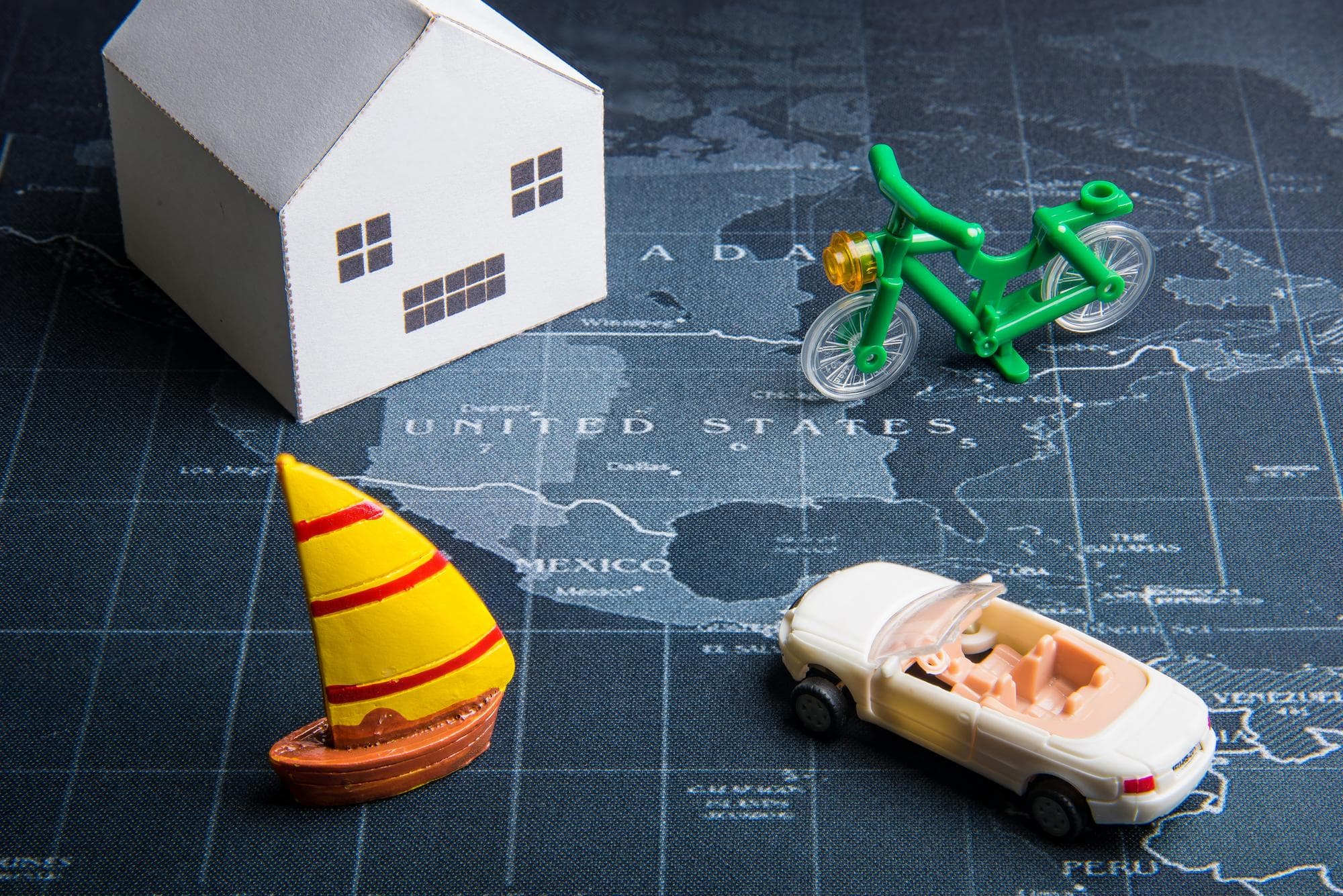 Model house with car and bicycle on map, symbolizing Gold Coast insurance rebuild process.
