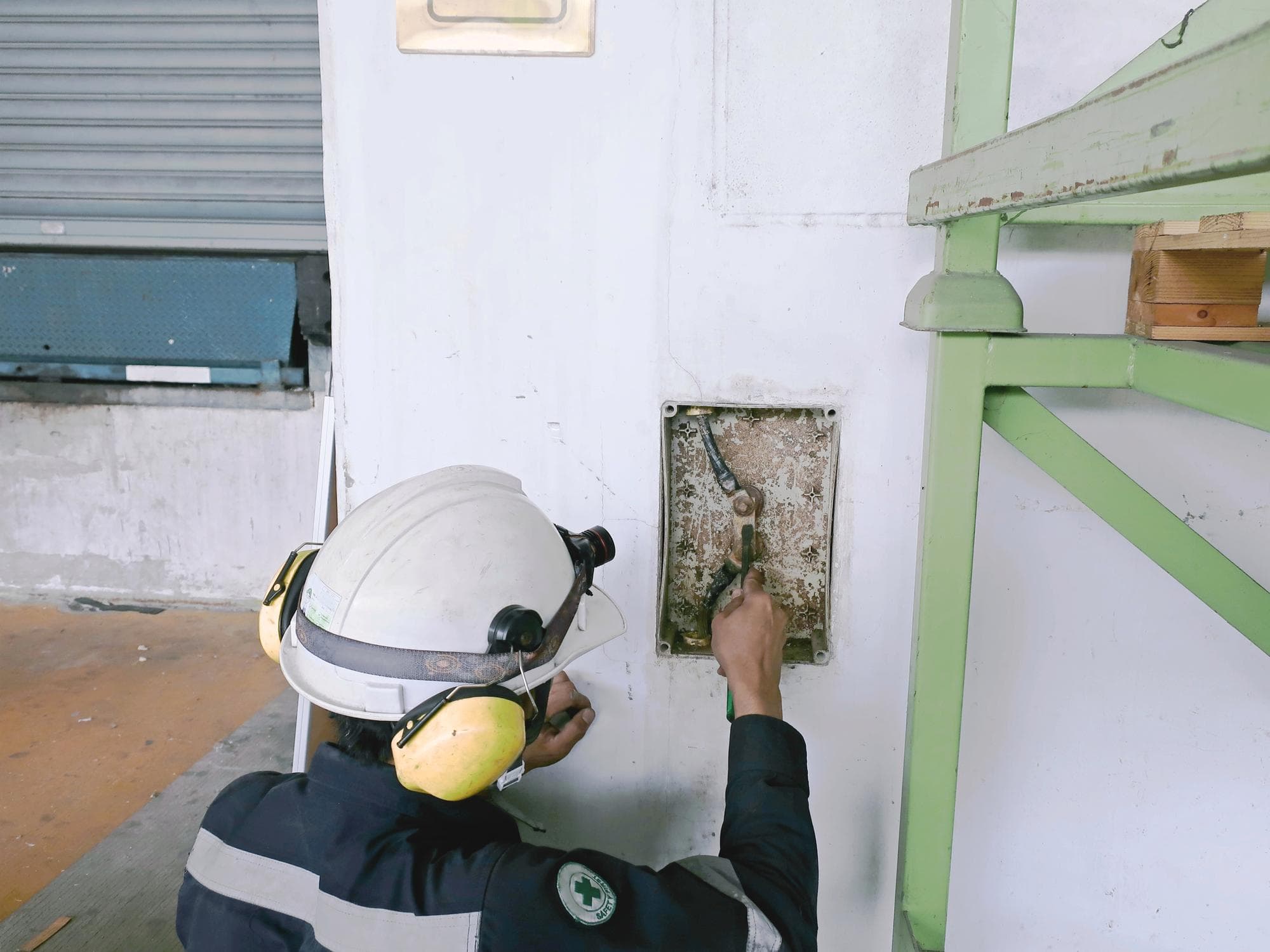 Worker in protective gear inspecting potential asbestos during Gold Coast renovation.