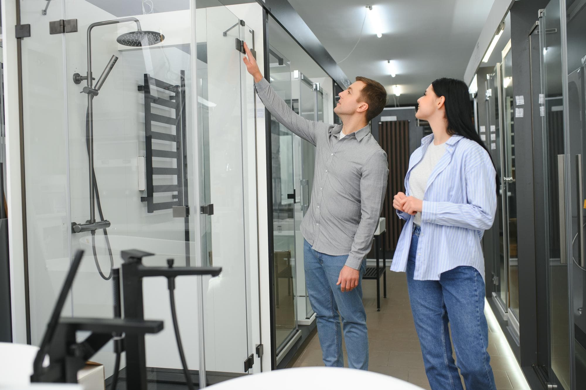 Couple examining walk in shower options in store for bathroom renovation.